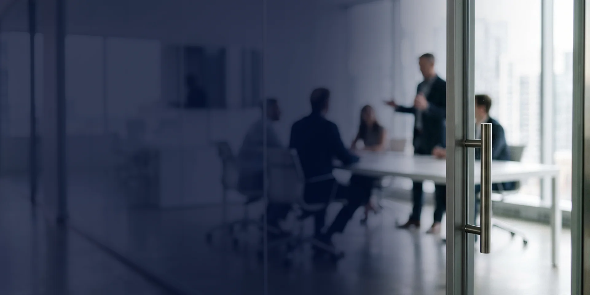 Colleagues meeting in a glass-walled office
